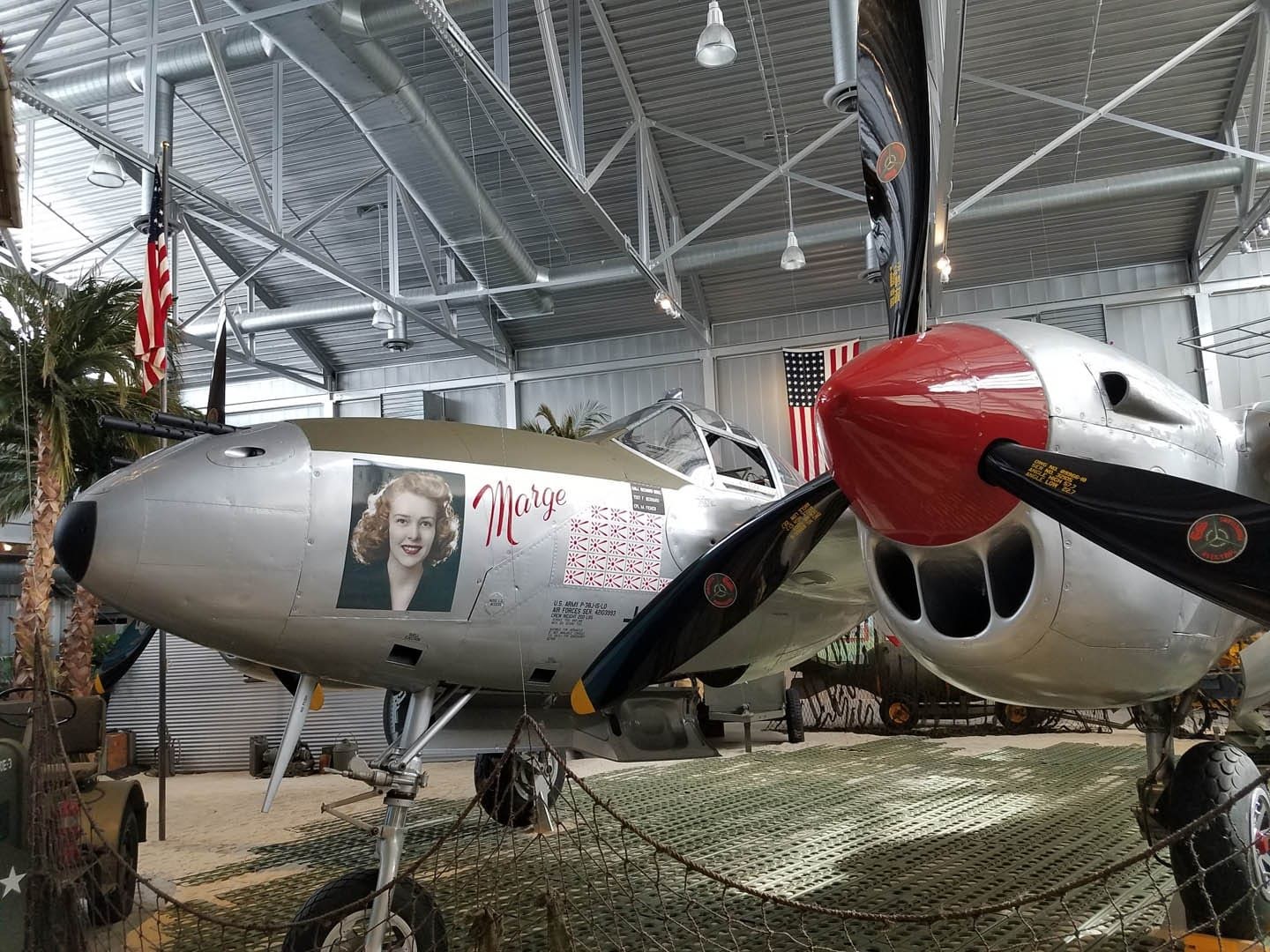 The restored P-38 Lightning inside the Richard I. Bong Veterans Museum, with the American flag behind it